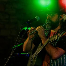 Holmes, in Prague, playing a tin whistle and guitar