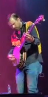 Walker attempting to play his banjo at a renovated church in Tennessee